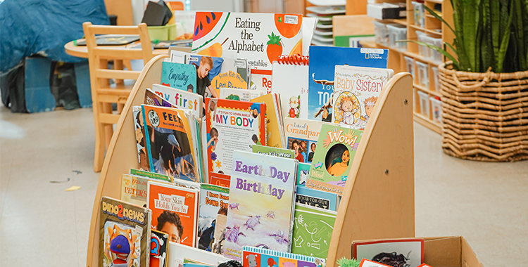Close-up of a  wooden bookshelf filled with picture books at a YMCA Child Care centre.