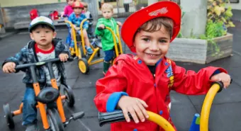 toddlers riding tricycles at YMCA Licensed Care program