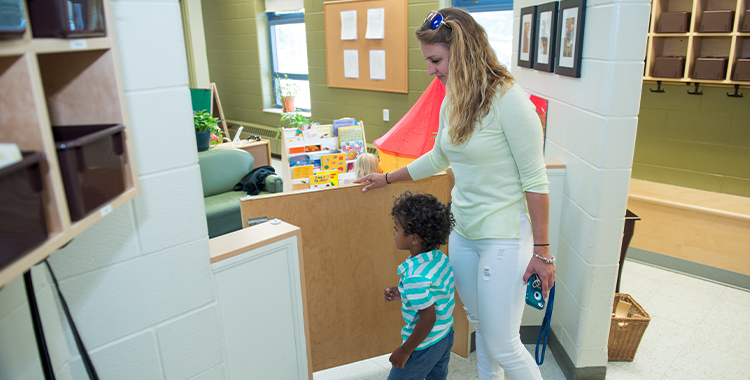 A parent and a child enter the door of a YMCA child care centre
