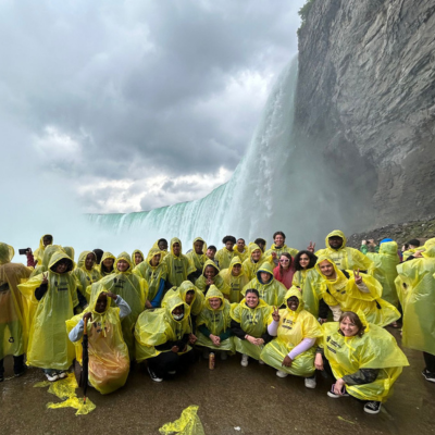 Toronto and Halifax youths posing against the backdrop of Niagara Falls, wearing bright yellow rain ponchos.