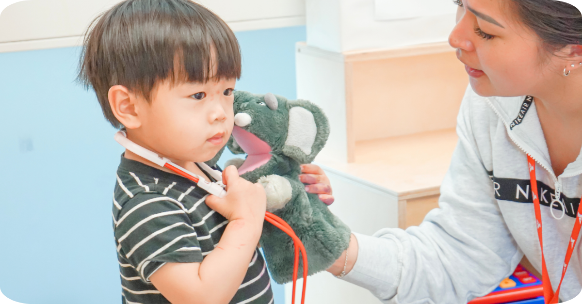 Child playing with a zebra and rhinoceros toy at a table in a calm YMCA preschool room.