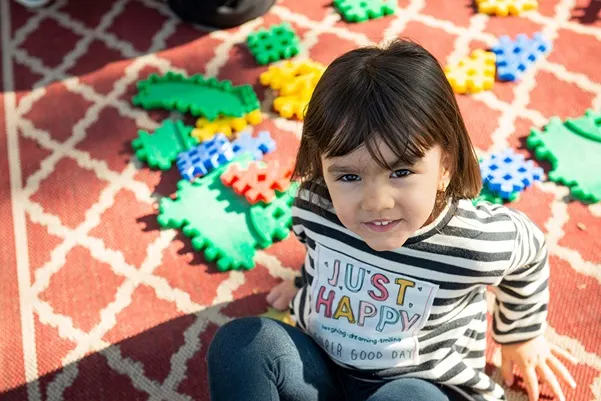 a young child playing with puzzle pieces