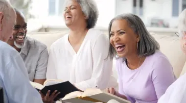 elders holding books and laughing