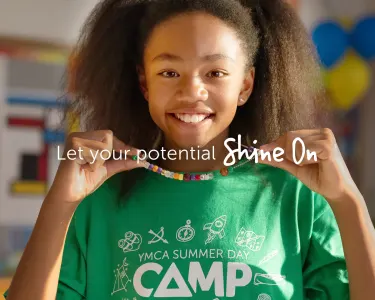 Three campers outdoor, smiling. One camper is holding a soccer ball