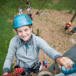 girl in helmet rock climbing