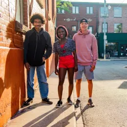 three teens on the sidewalk
