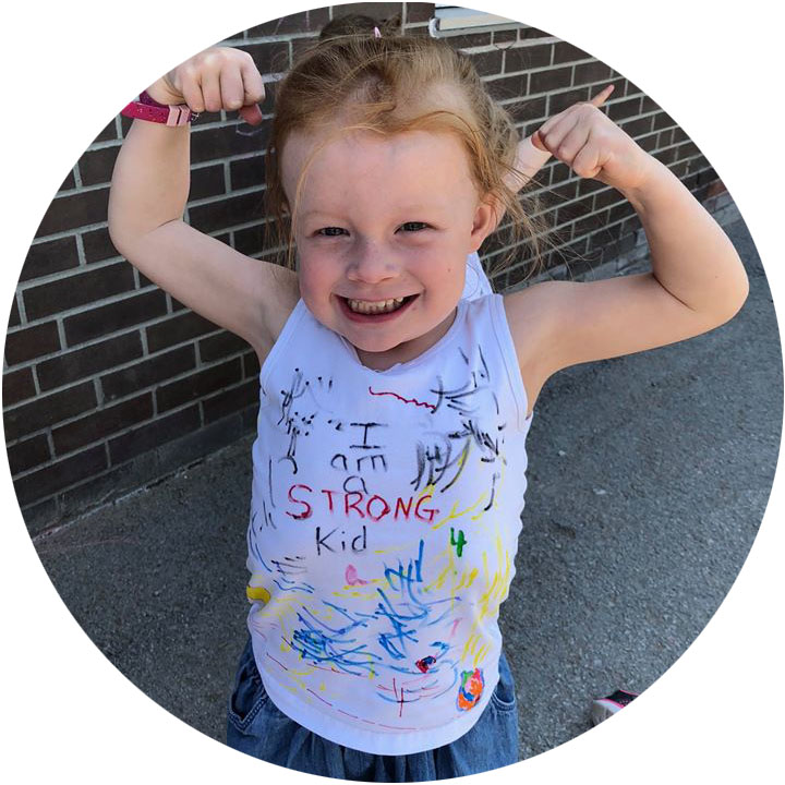 child wearing shirt that says "I am a strong kid" while showing off their biceps