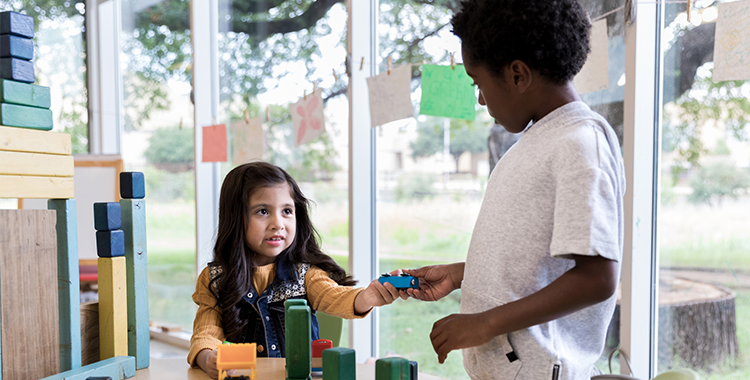 A child shares toys with their preschool friend