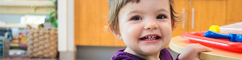 A smiling baby girl in a child care centre
